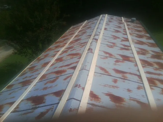 Rusted metal roof panels with new wood purlins before replacement — Storm Damage Roof Repair in Youngsville by Roofing Brothers